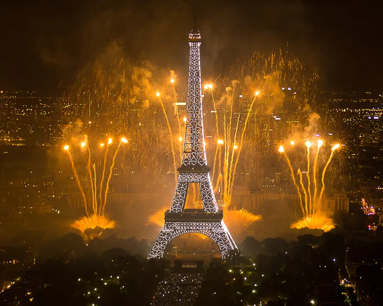 Eiffel Tower illuminated with golden fireworks during Bastille Day celebrations in Paris France