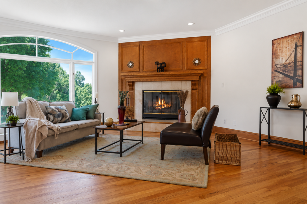 Professionally staged living room with fireplace and hardwood floors by Harvard Home Services
